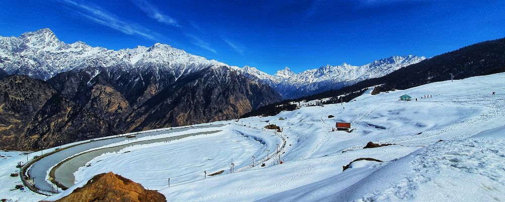 Auli ke snow-covered Himalayan slopes par skiing ka nazara